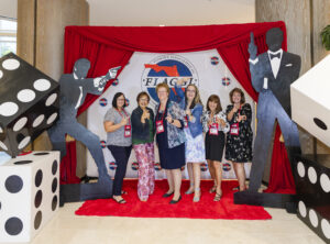 Theme night at the 2025 FLAGGL conference and attendees posting with a 007 themed backdrop