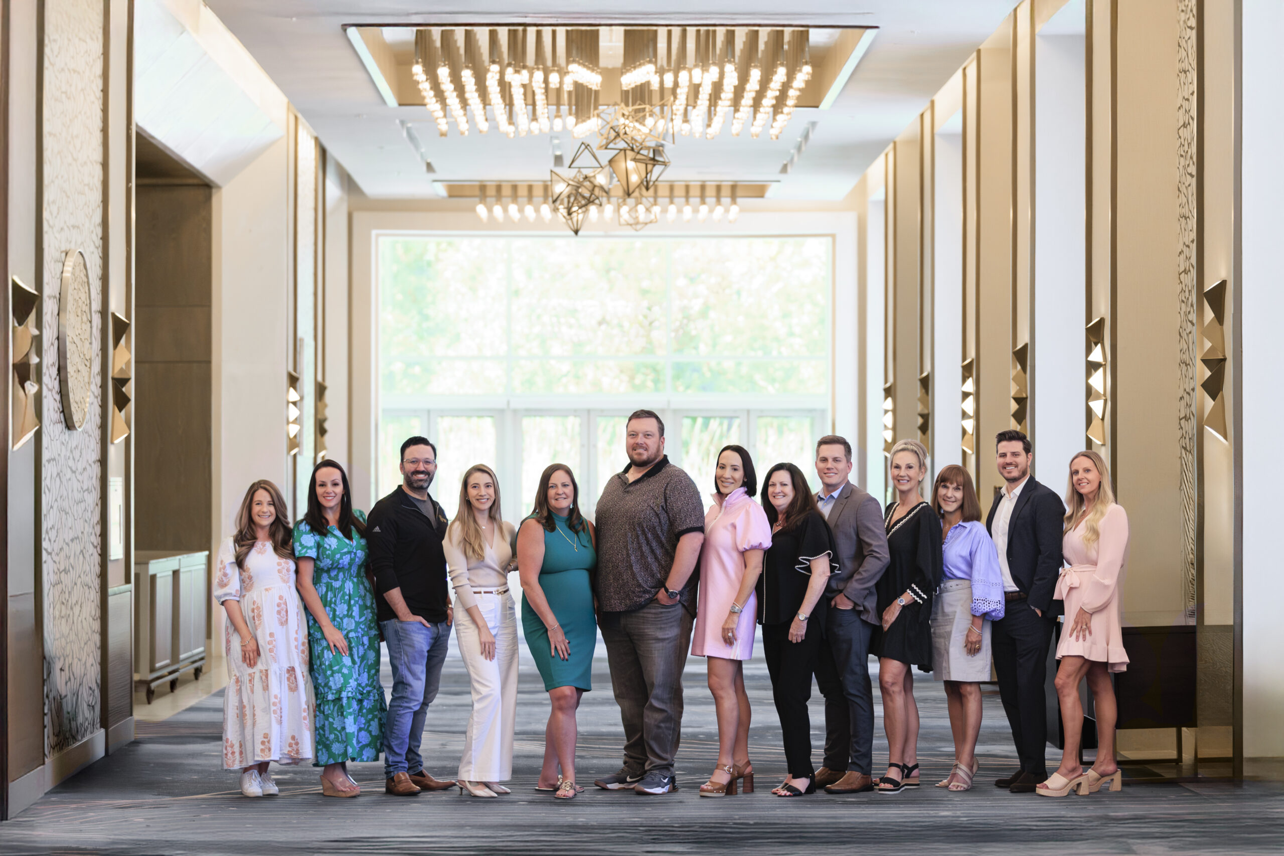 13 FLAGGL Board members, posing in a hotel conference hallway